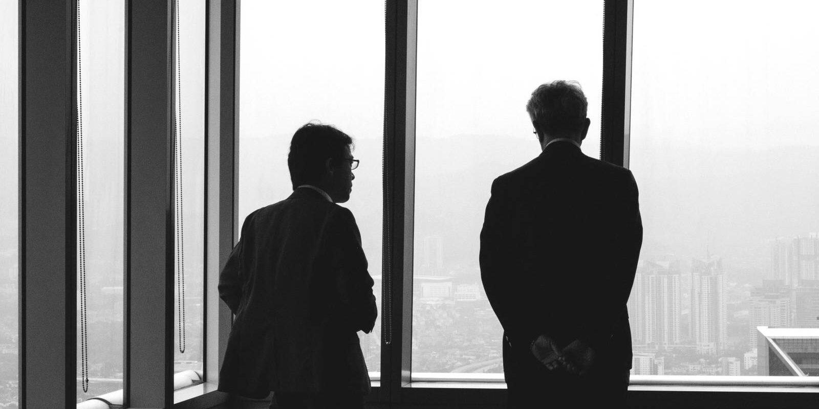 Dos personas conversan frente a una ventana